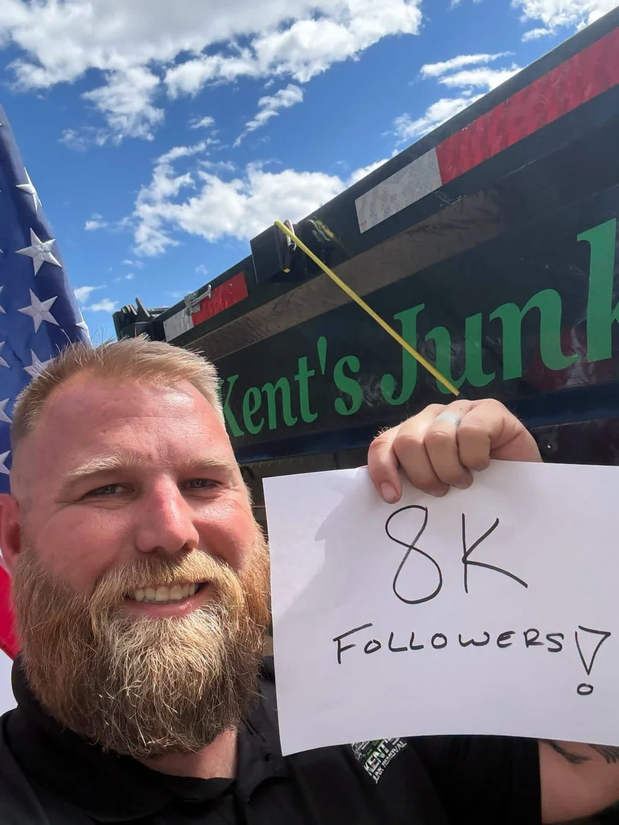 Kent celebrating 8,000 Facebook followers beside his junk removal truck